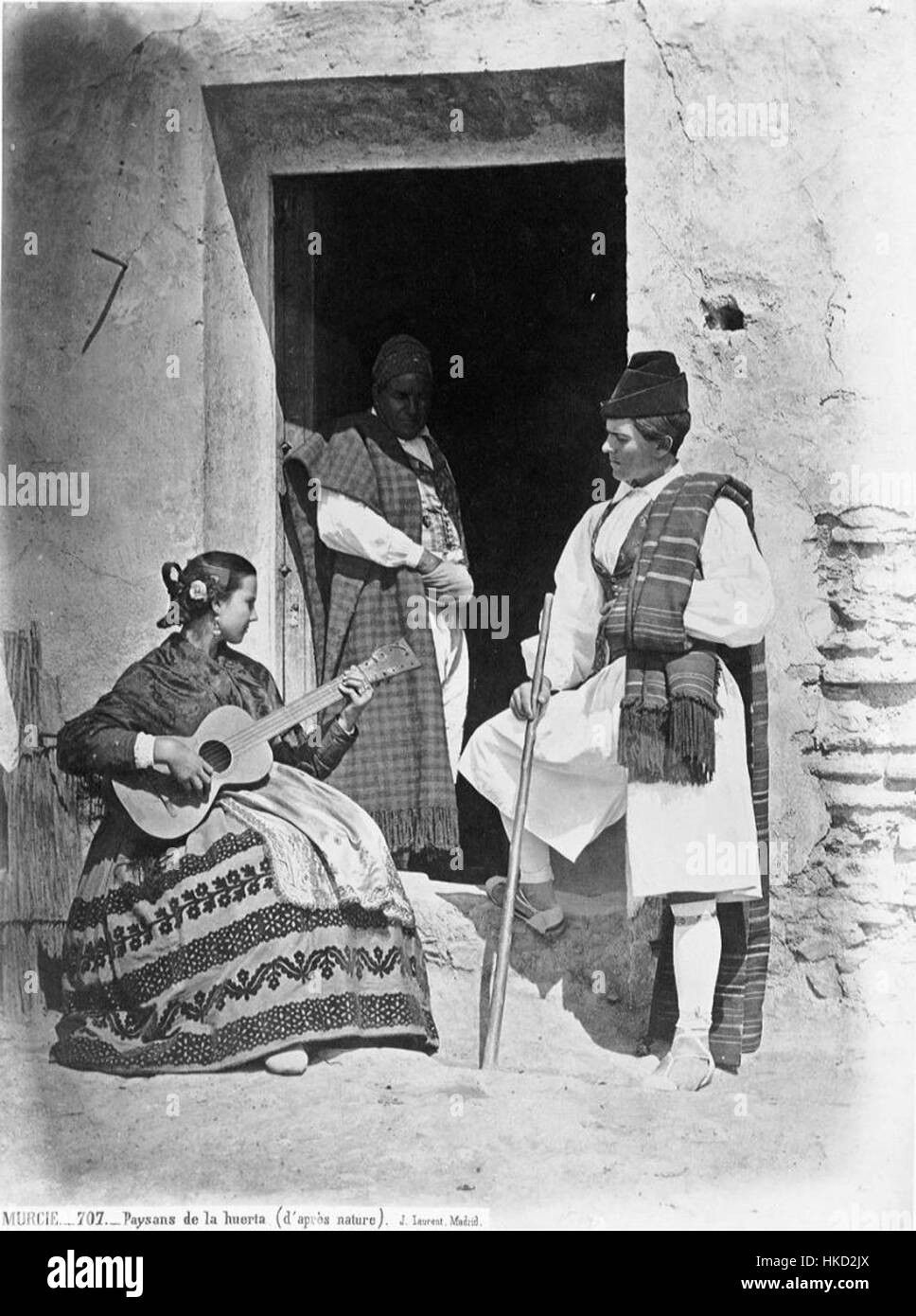 Cette peinture espagnole, 'Huertanos Tocando el Guitarro', représente la vie rurale avec des paysans jouant de la guitare. La scène capture l'essence culturelle de la musique traditionnelle et le mode de vie agraire de l'Espagne. Banque D'Images