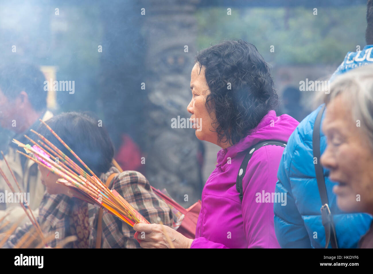 Fidèles en prière tout en offrant d'encens dans Sik Sik Yuen Wong Tai Sin temple à Hong Kong Banque D'Images