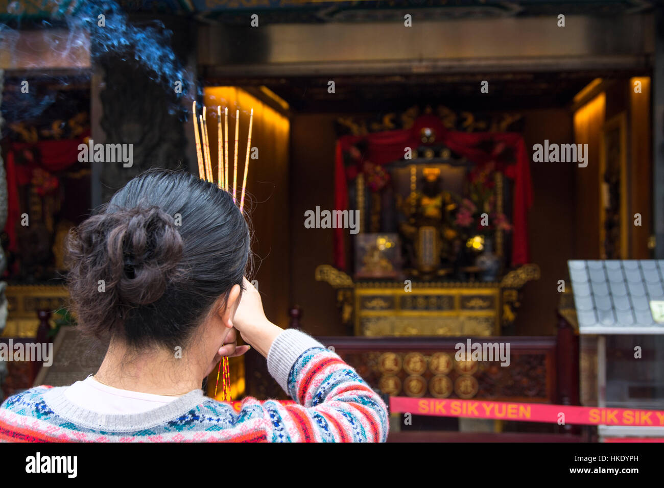 Fidèles en prière tout en offrant d'encens dans Sik Sik Yuen Wong Tai Sin temple à Hong Kong Banque D'Images