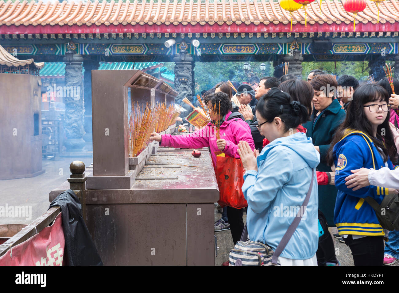 Fidèles en prière tout en offrant d'encens dans Sik Sik Yuen Wong Tai Sin temple à Hong Kong Banque D'Images