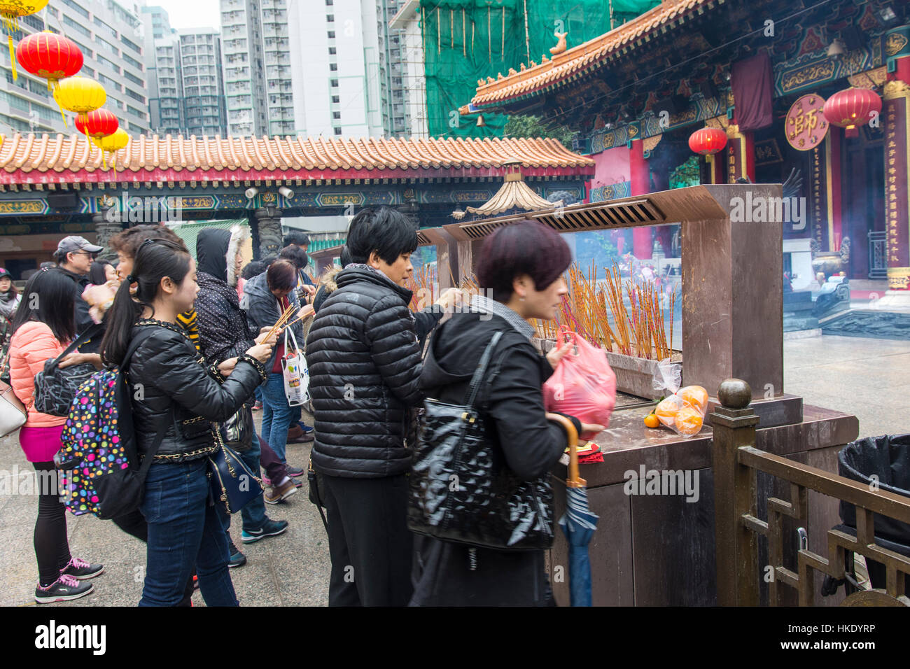 Fidèles en prière tout en offrant d'encens dans Sik Sik Yuen Wong Tai Sin temple à Hong Kong Banque D'Images