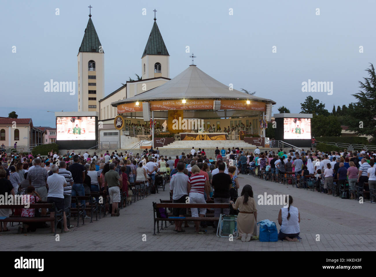 Des milliers de pèlerins venus assister à une messe dans la soirée se sont réunis sur la place derrière l'église Saint James. MEDJUGORJE, BOSNIE ET HERZÉGOVINE Banque D'Images