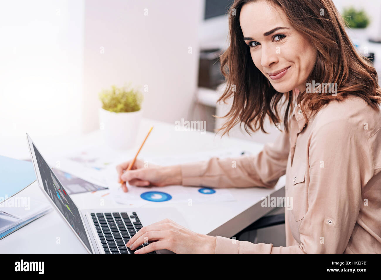 Cheerful young businesswoman travaillant au bureau Banque D'Images