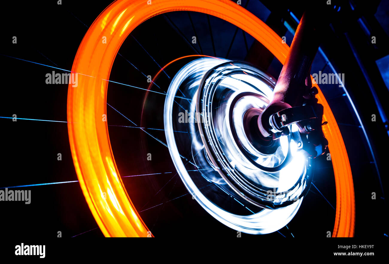 Spinning Bike roue avec feux orange et blanc sur fond sombre Banque D'Images