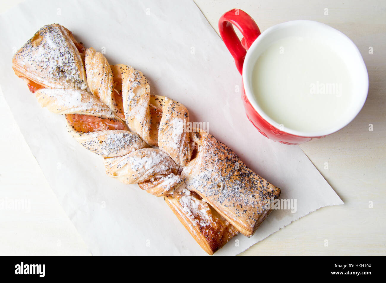 Feuilleté tressé avec de la confiture et un verre de lait Banque D'Images