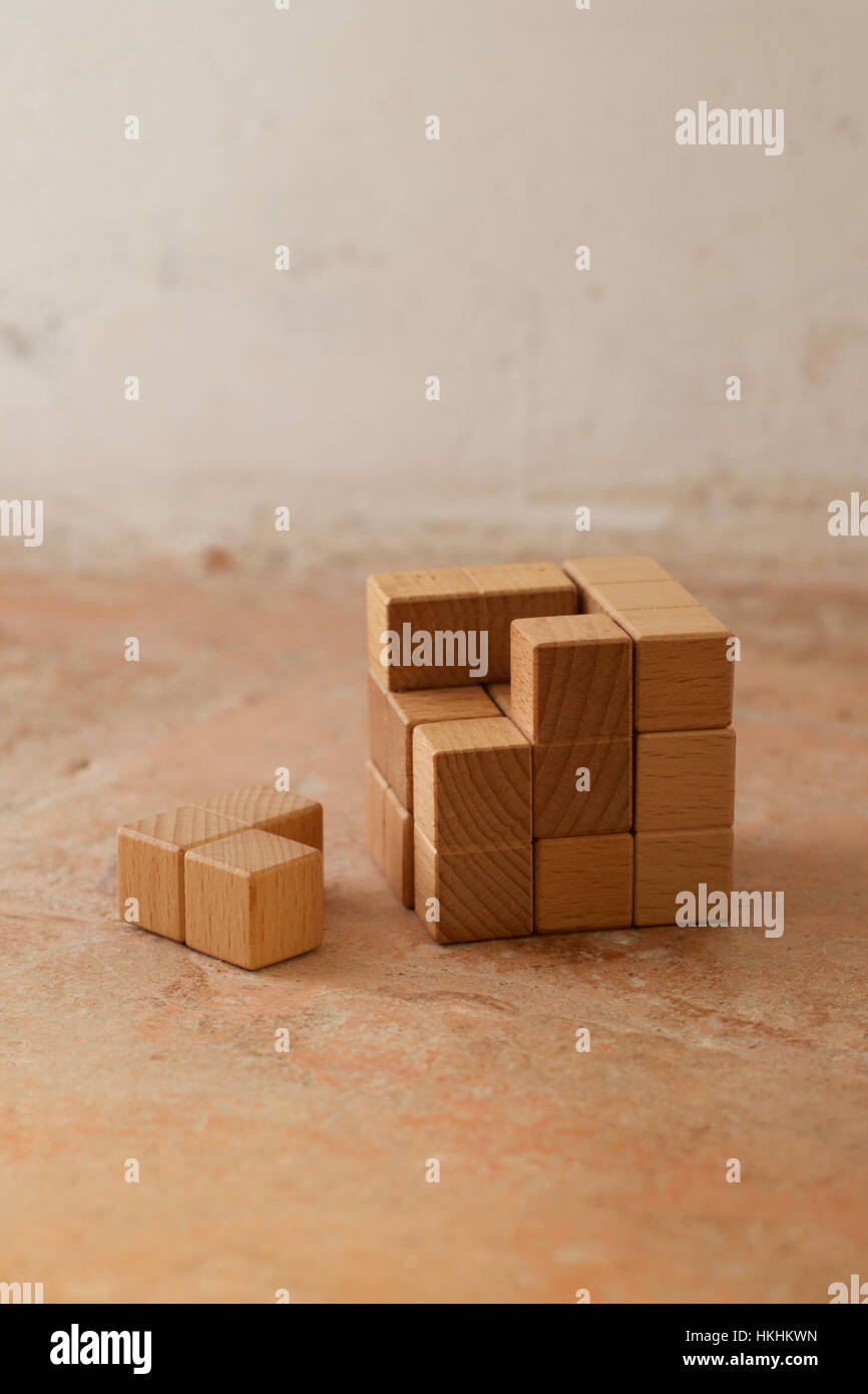Un cube de bois avec un morceau de puzzle pour terminer la forme Banque D'Images