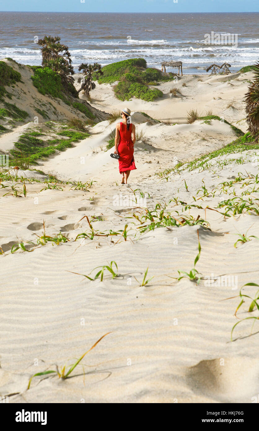 Femme en robe rouge, les dunes sur la côte, du delta du fleuve Tana, au Kenya Banque D'Images