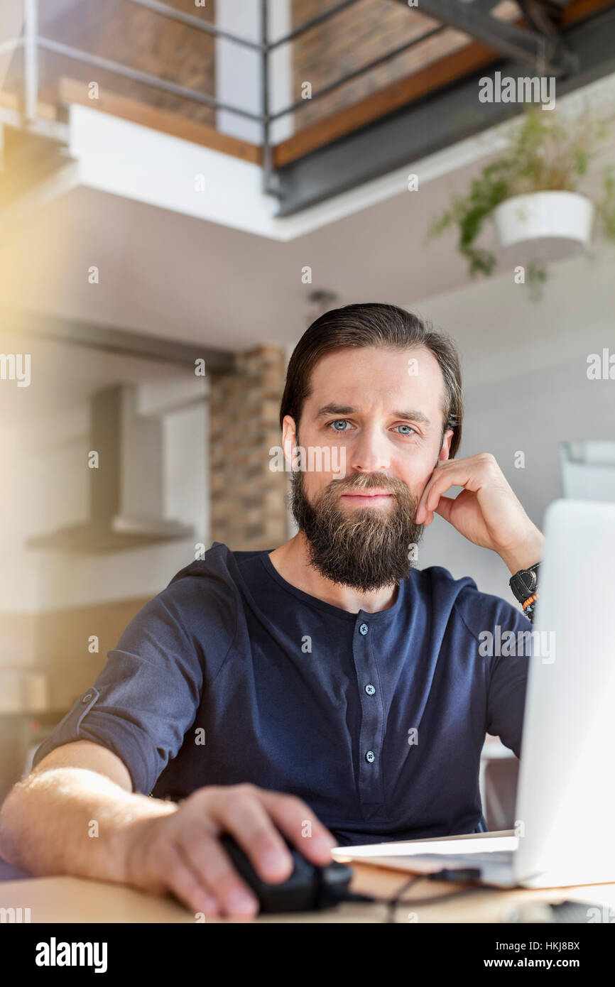 Portrait confiant homme design professional working at laptop in office Banque D'Images