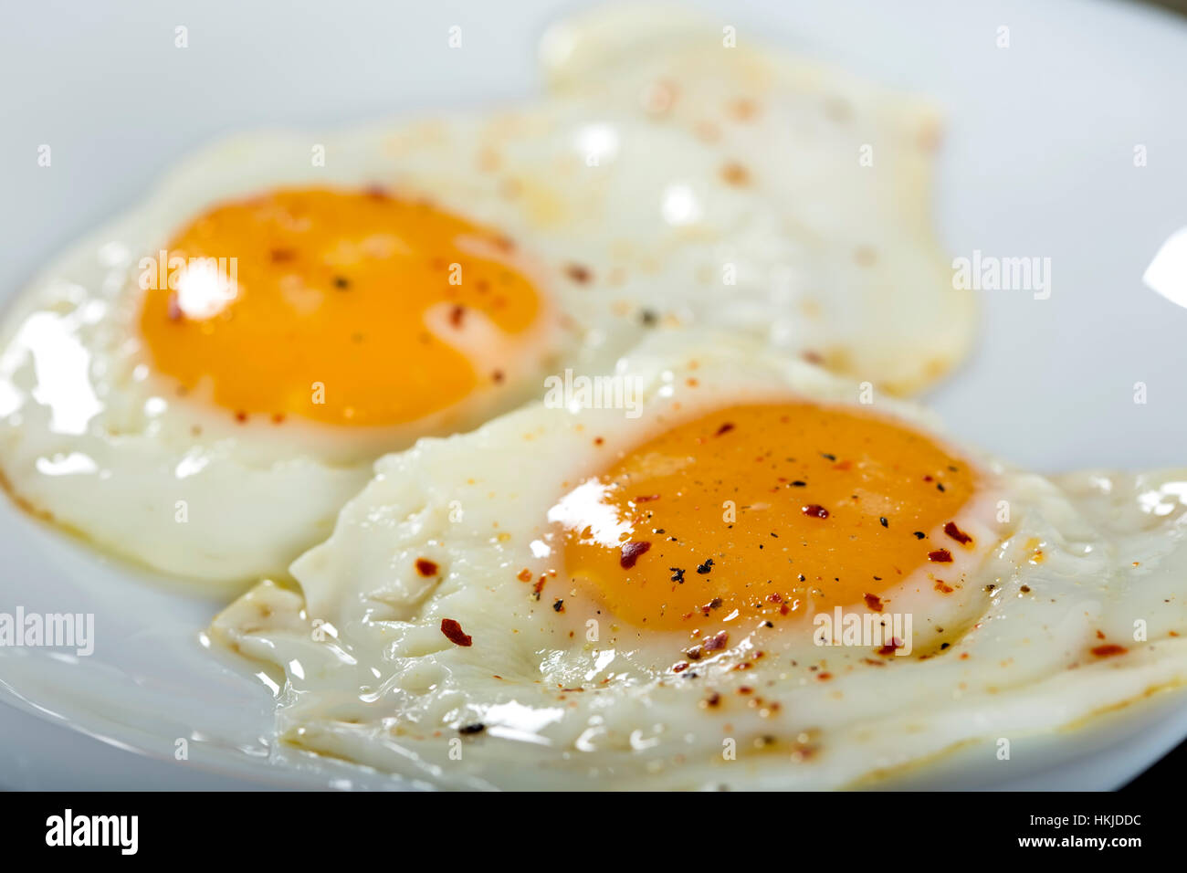 Deux œufs avec du poivre et piment séché sur la plaque Banque D'Images