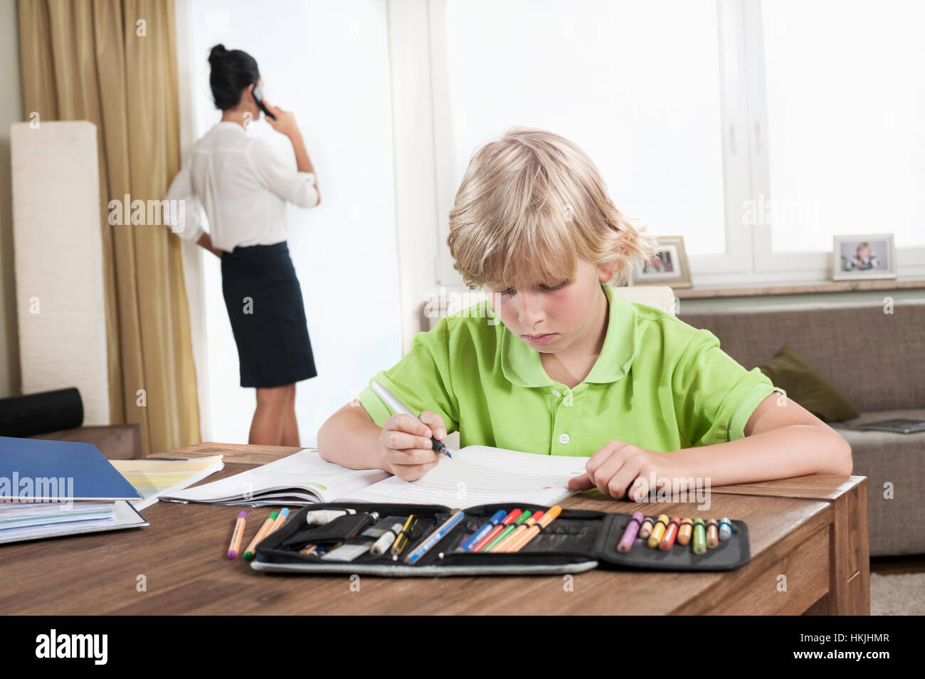 Boy studying alors que mère a appel,Bavière, Allemagne Banque D'Images