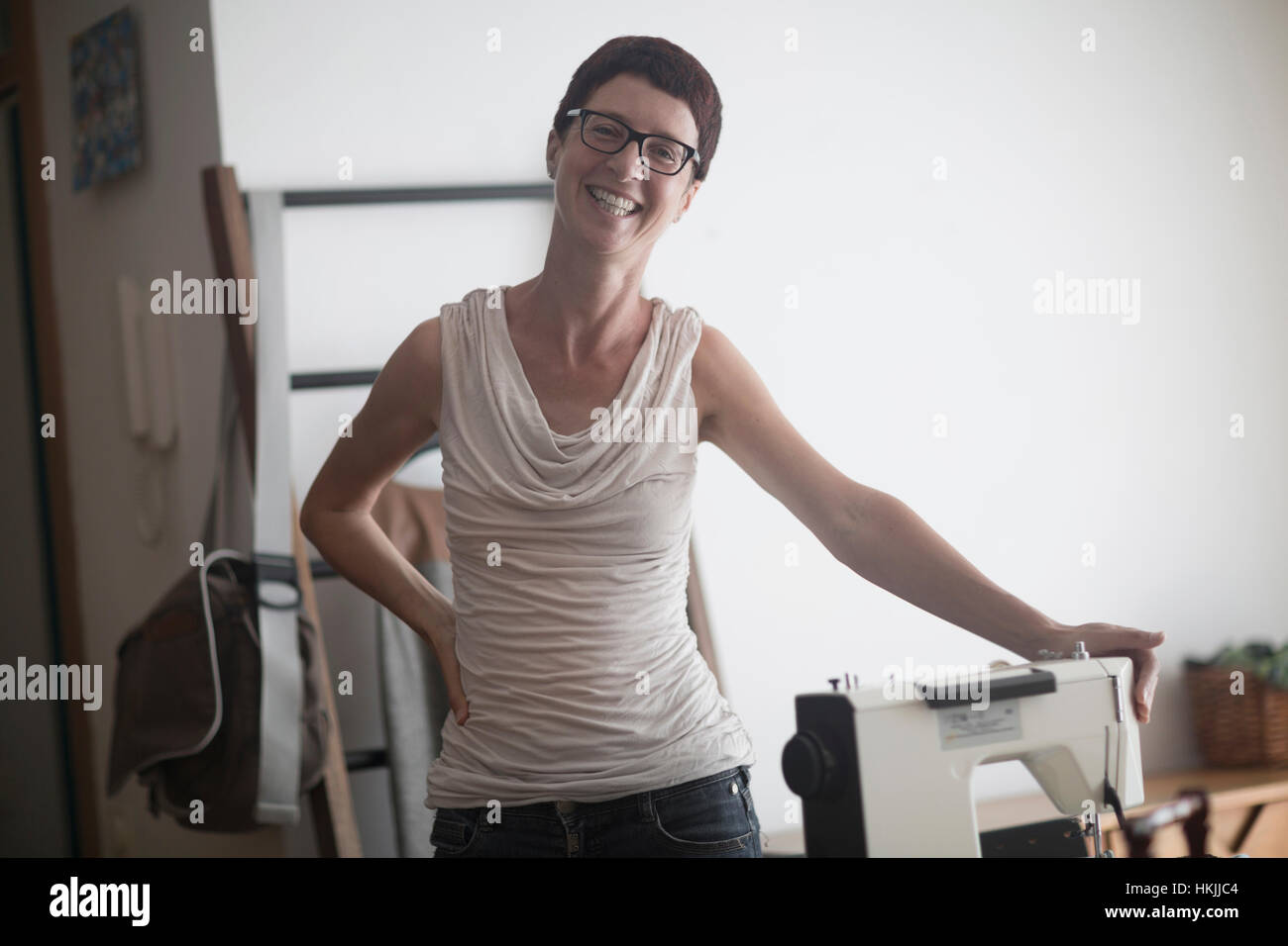 Femme souriante couturière avec machine à coudre, Freiburg im Breisgau, Bade-Wurtemberg, Allemagne Banque D'Images