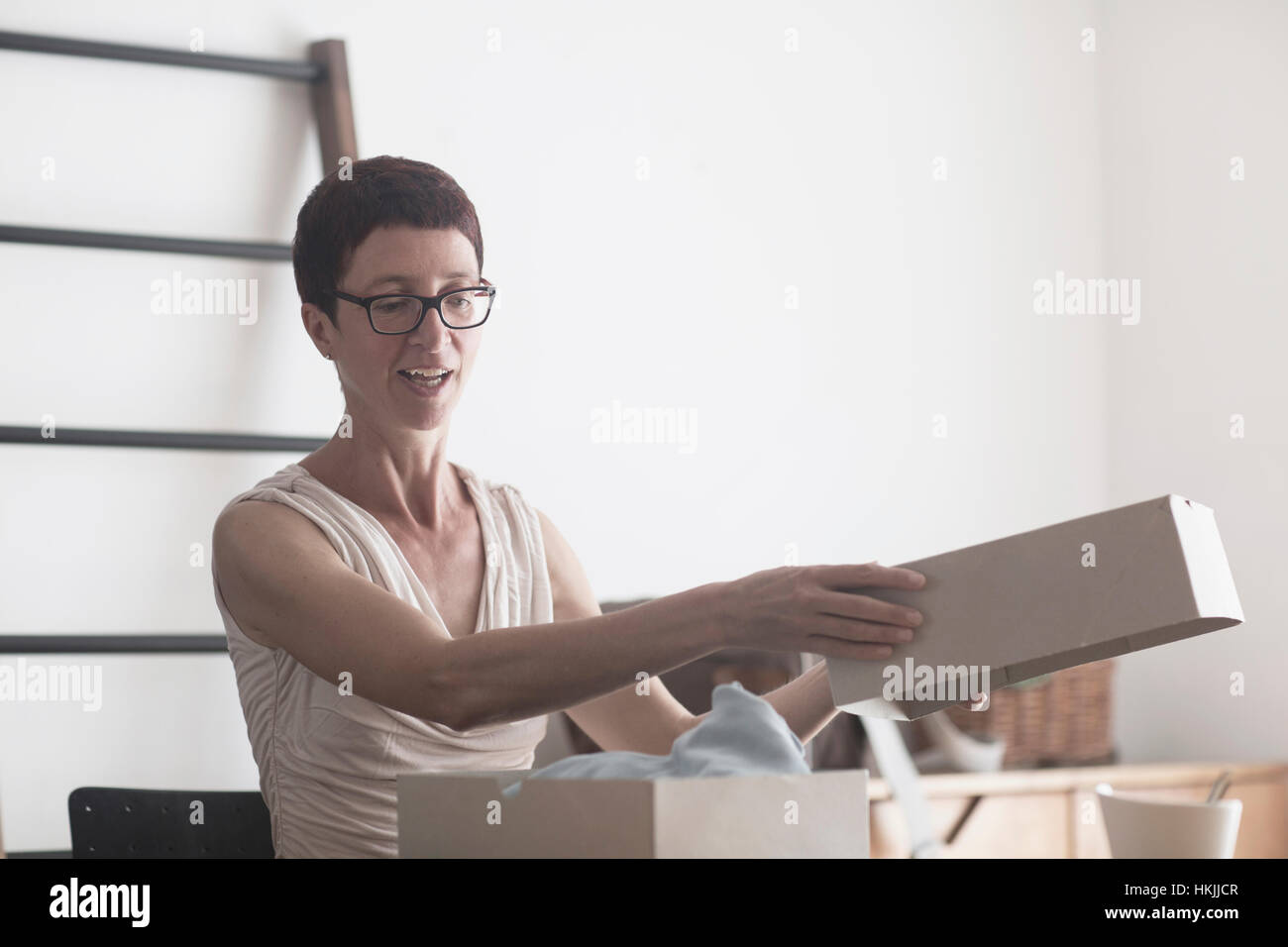Mature femme vêtement d'ouverture dans la boîte, Freiburg im Breisgau, Bade-Wurtemberg, Allemagne Banque D'Images
