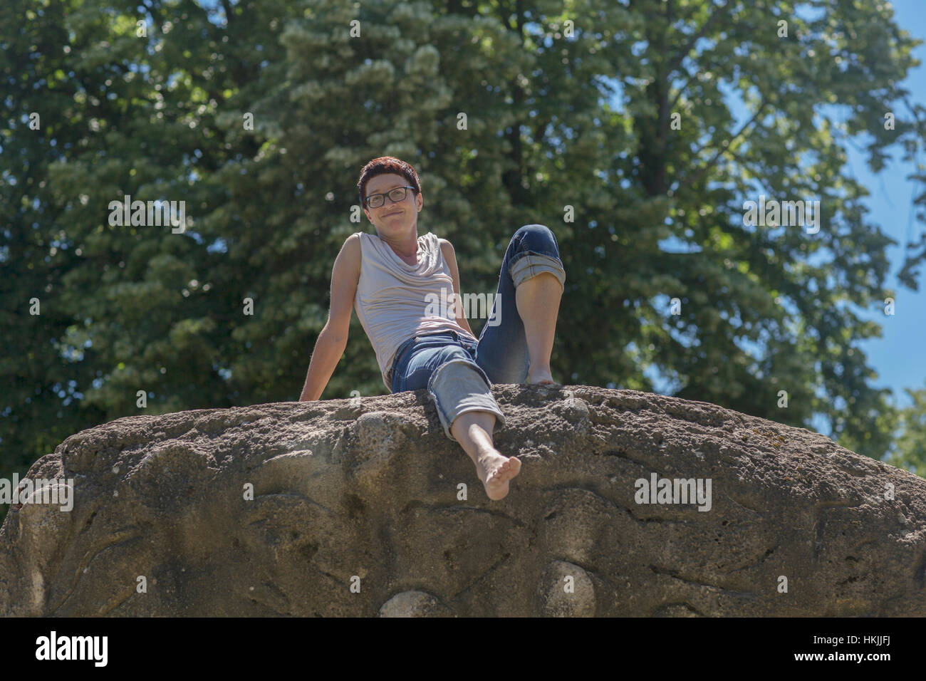 Mature Woman sitting on rock et souriant, Freiburg im Breisgau, Bade-Wurtemberg, Allemagne Banque D'Images