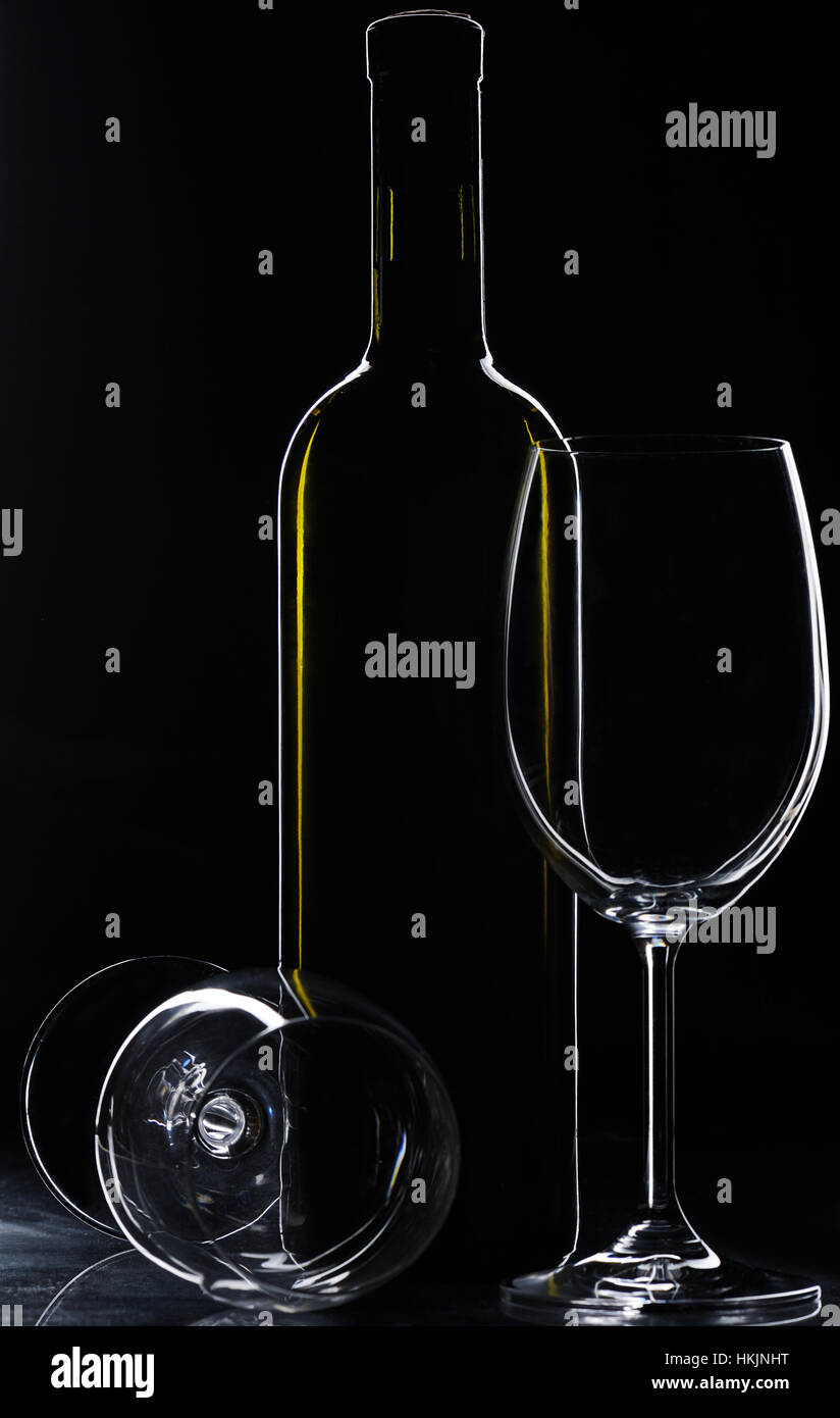 Bouteille de vin et les verres vides sur fond noir Banque D'Images
