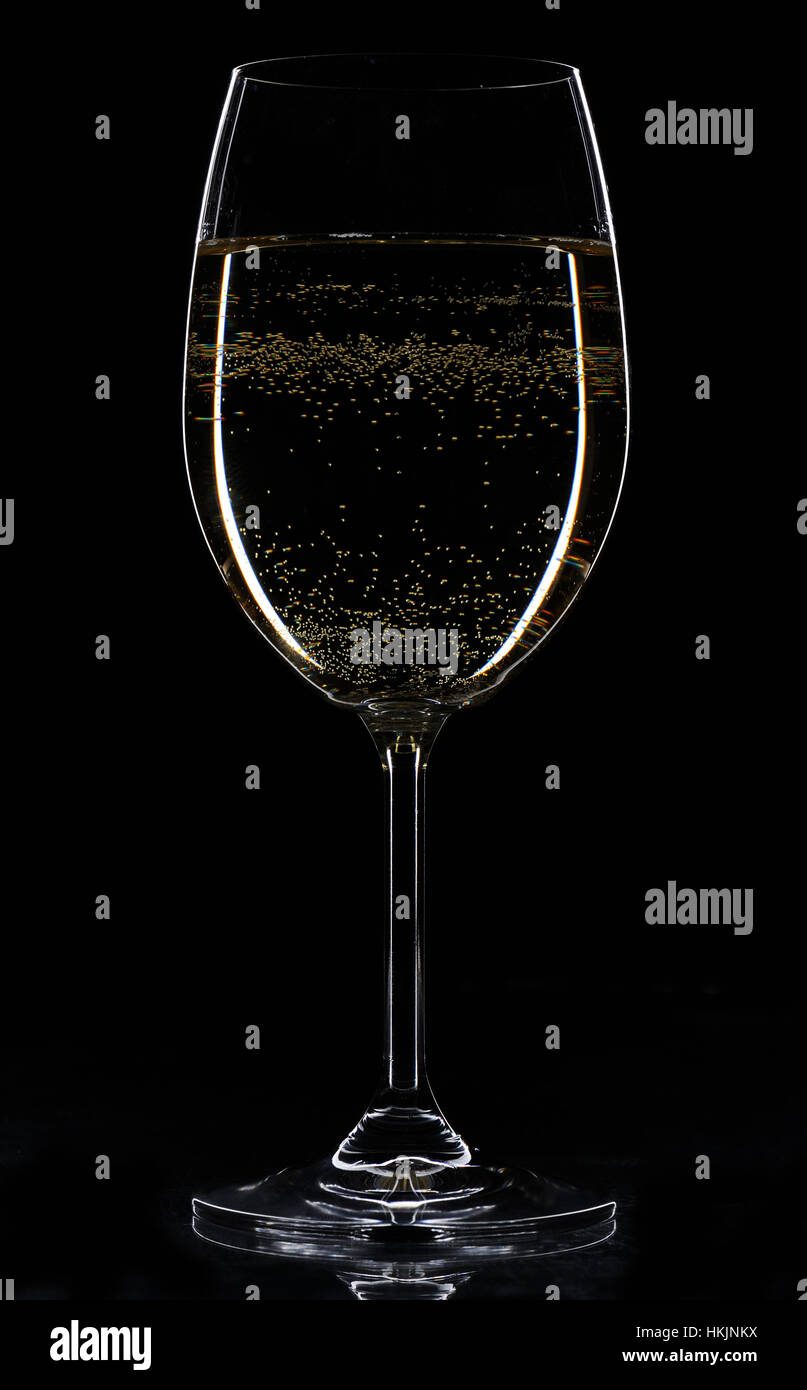 Verre à vin blanc avec éclat dans l'arrière-plan noir Banque D'Images