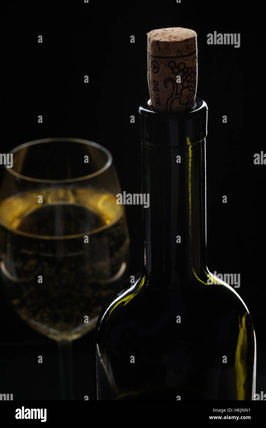 Close up de bouteille de vin et le verre sur fond noir Banque D'Images
