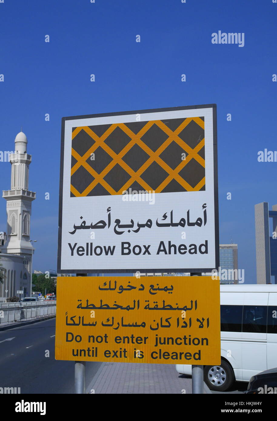 Signalisation routière en arabe et en anglais pour informer d'une boîte jaune junction à venir, Manama, Royaume de Bahreïn Banque D'Images