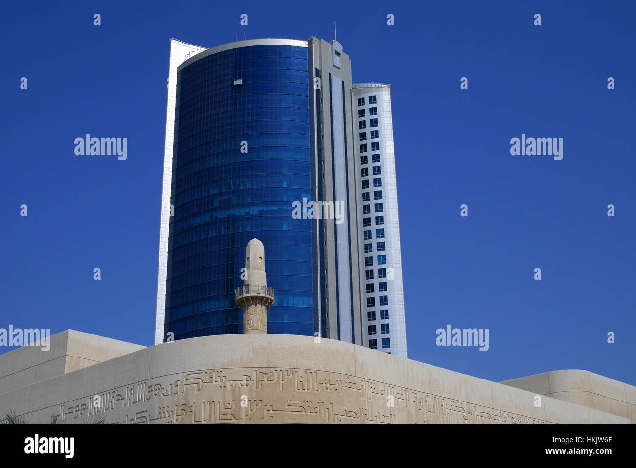 Minaret de la Beit al-Coran vu contre la façade d'une tour de bureaux dans le quartier diplomatique, à Bahreïn Banque D'Images