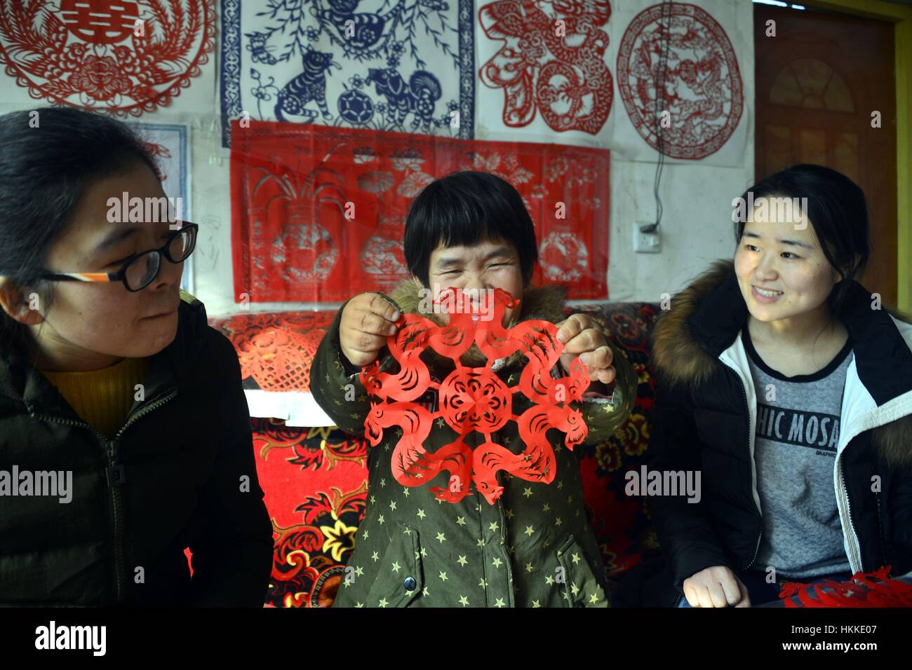 Qingdao, Qingdao, Chine. 25 Jan, 2017. Qingdao, Chine - 25 janvier 2017 : (usage éditorial uniquement. Chine).L'artiste folklorique Guo Shuhua rend le papier-coupes dans Jiangzhuang Village de Liaocheng, dans la province du Shandong en Chine de l'Est, 25 janvier 2017, marquant la fête du printemps. Guo Shuhua, 1,1 mètres de haut femme diagnostiquée avec nanisme, a fait des coupures de papier pour plus de 10 ans. Crédit : SIPA Asie/ZUMA/Alamy Fil Live News Banque D'Images