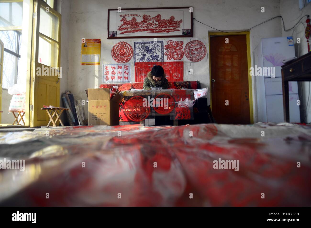 25 janvier 2017 - Shanghai, Shanghai, Chine - SHANGHAI, CHINE - 25 janvier 2017 : (usage éditorial uniquement. Chine)..L'artiste folklorique Guo Shuhua rend le papier-coupes dans Jiangzhuang Village de Liaocheng, la Chine de l'est la province de Shandong, 25 janvier, 2017, marquant la fête du printemps. Guo Shuhua, 1,1 mètres de haut femme diagnostiquée avec nanisme, a fait des coupures de papier pour plus de 10 ans. (Crédit Image : © SIPA l'Asie via Zuma sur le fil) Banque D'Images