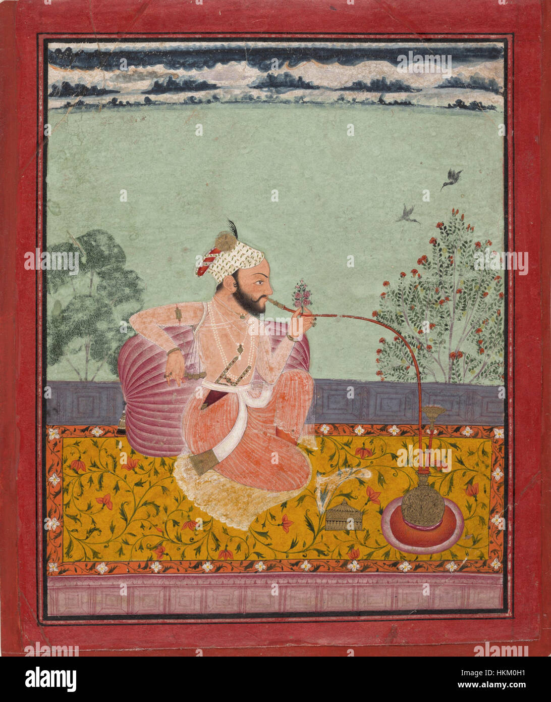 Cette œuvre de la région de Kota, créée entre 1690 et 1710, représente un personnage fumant un narguilé. La peinture reflète les pratiques culturelles et sociales de l'époque, capturées dans le riche style du Rajasthani compris Banque D'Images