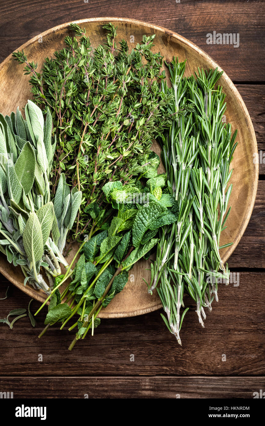 Diverses fines herbes, Romarin, Thym, Menthe et sauge sur fond de bois Banque D'Images