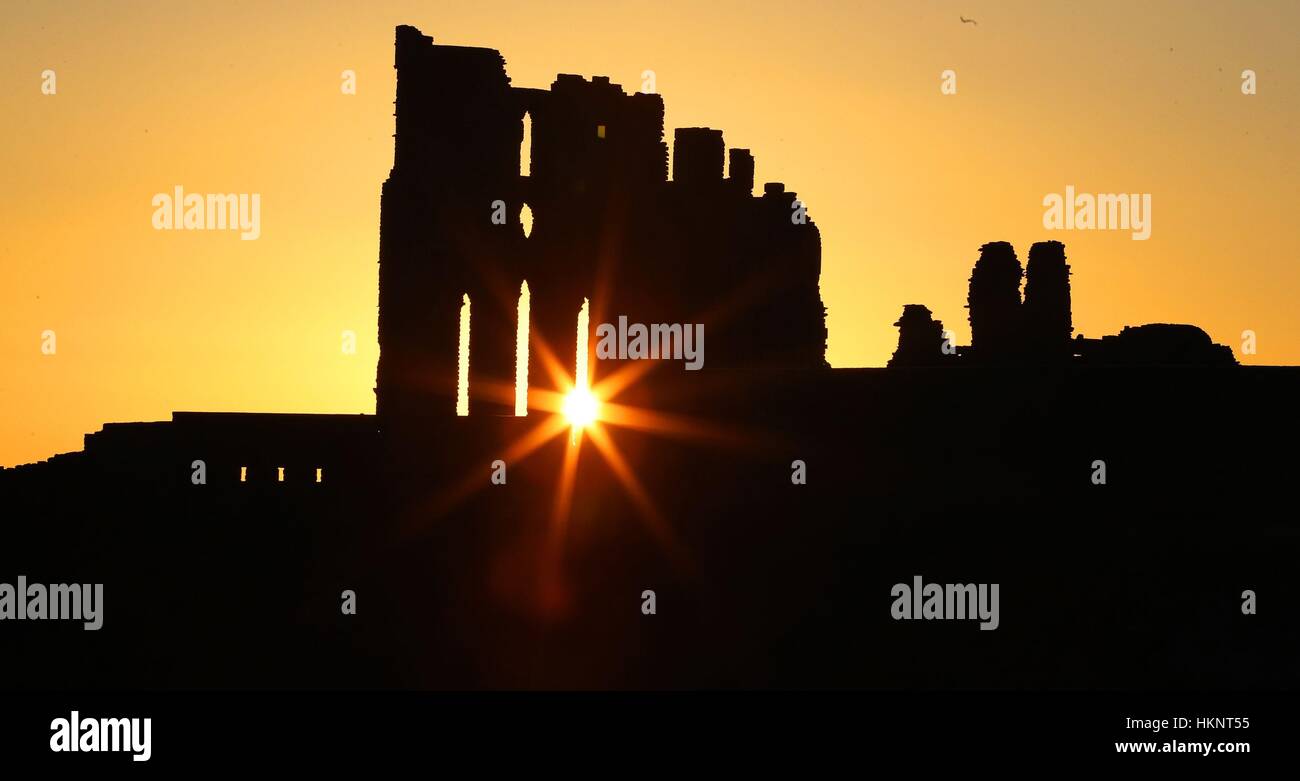 Le soleil se lève sur Tynemouth Priory sur la sur la côte nord-est. Banque D'Images