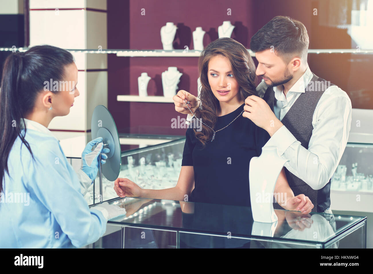 Collier homme essayant pour sa femme à bijoux. Banque D'Images