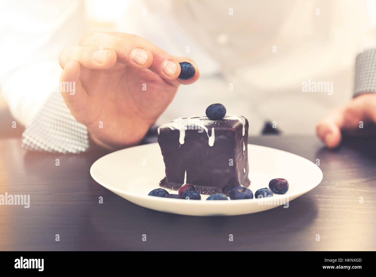 Chef cuisinier de préparer le dessert, mettre sur un gâteau au chocolat aux bleuets Banque D'Images