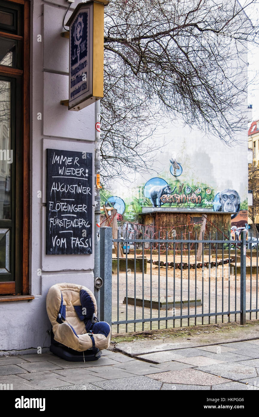 Le siège de l'enfant abandonné sur la chaussée à l'extérieur à côté de pub Aire de jeux pour enfants, Berlin Banque D'Images