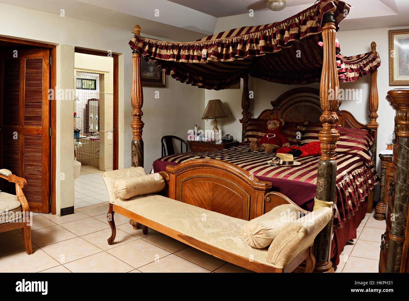 Chambre avec lit en bois rideaux rayures vintage Banque D'Images