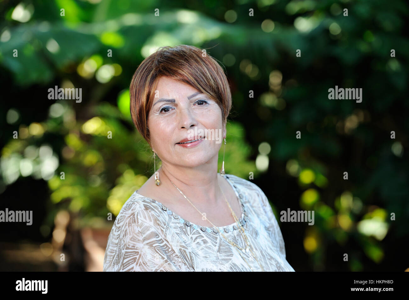 Portrait de vieille dame souriante en vert jardin Banque D'Images