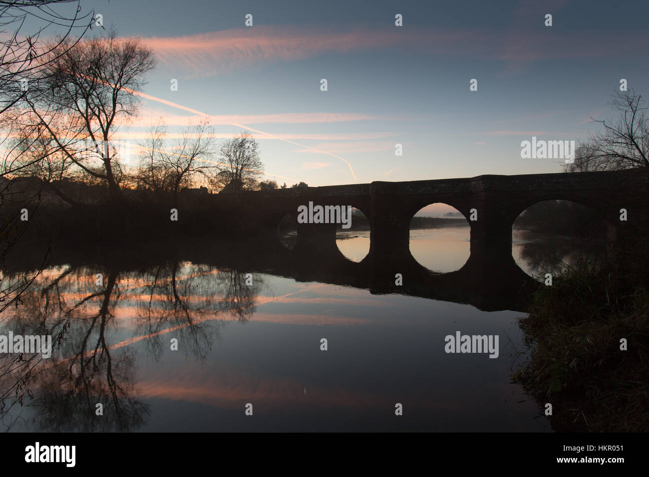 Hespérie de village, en Angleterre. Vue du coucher de soleil pittoresque du 14ème siècle figurant 1 e année Holt médiévale Pont sur la rivière Dee. Banque D'Images