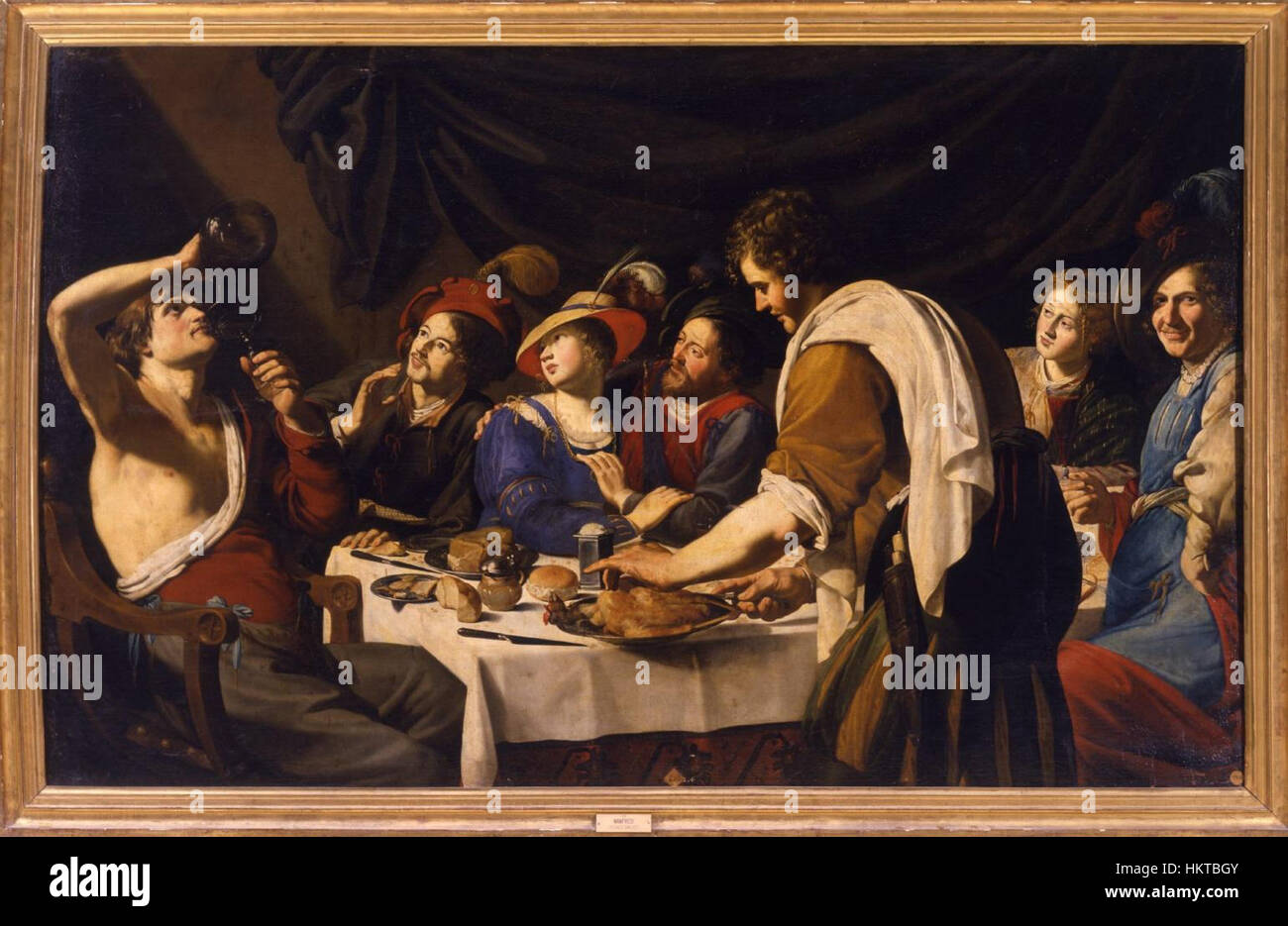 Une peinture à l'huile de Bartolomeo Manfredi représentant une scène de banquet, mettant en valeur la dynamique sociale de l'époque avec des figures vibrantes et des expressions détaillées de fête et de célébration. Banque D'Images