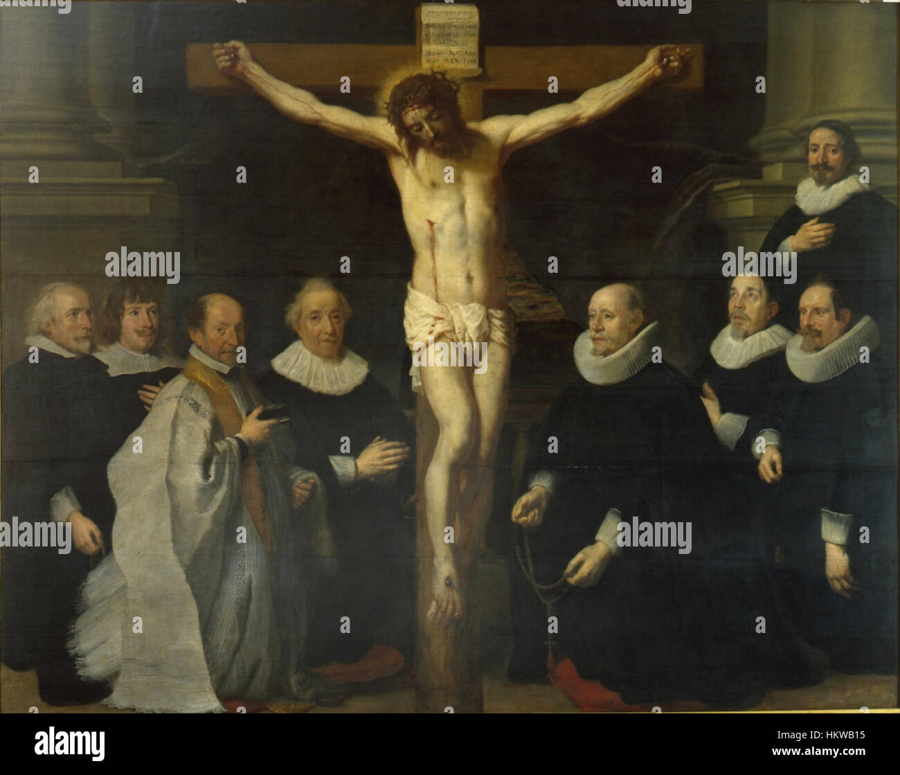 'Les patrons du Béguinage priant le Christ sur la Croix' de Gaspar de Crayer représente une scène religieuse montrant la dévotion des patrons dans un cadre médiéval. L'œuvre reflète à la fois les thèmes religieux et le style détaillé de la période baroque flamande. Banque D'Images