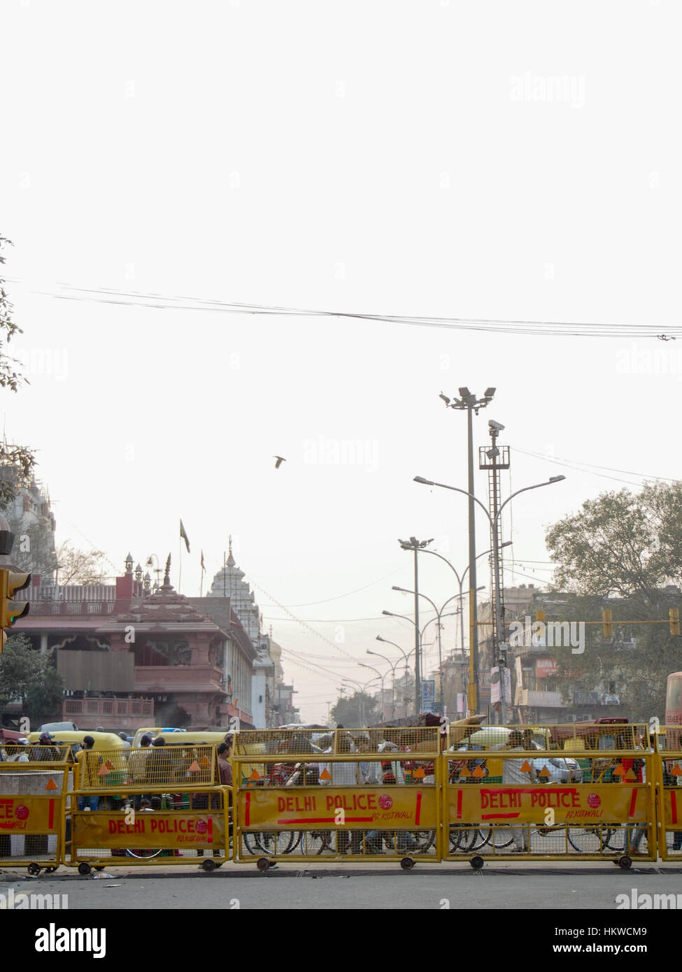 Des foules de gens sont tenus en échec par des barrières de police jaune dans les rues de la ville de Delhi en Inde. Banque D'Images