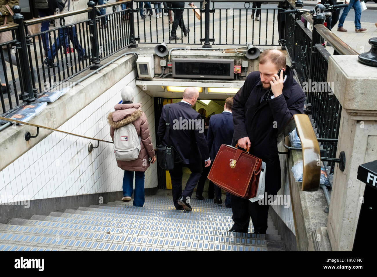 Man holding Serviette en cuir parle sur téléphone mobile à l'entrée de la station de métro Oxford Circus, Londres. UK Banque D'Images