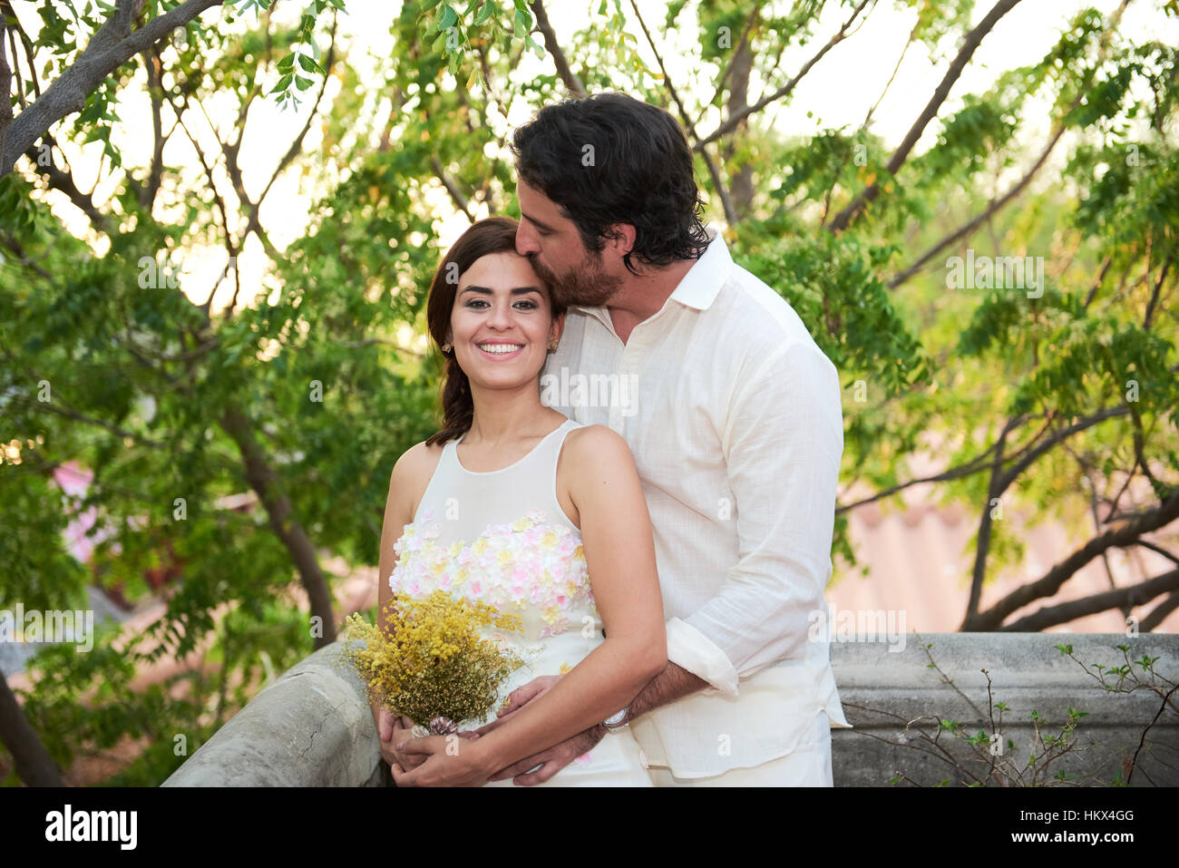 Groom kissing bride coucher du soleil sur fond clair Banque D'Images