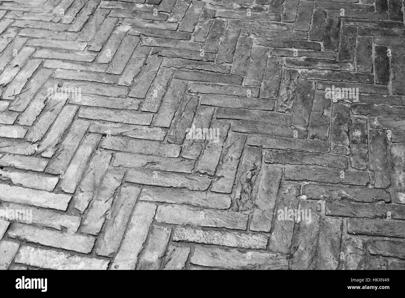 La texture des rues humides bordées de briques en pierre Banque D'Images