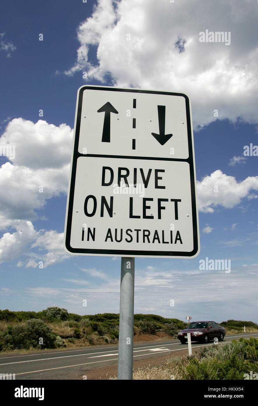 Panneau de circulation 'drive gauche' sur l'autoroute et de ciel bleu avec des nuages blancs dans l'arrière-plan, Victoria, Australie Banque D'Images