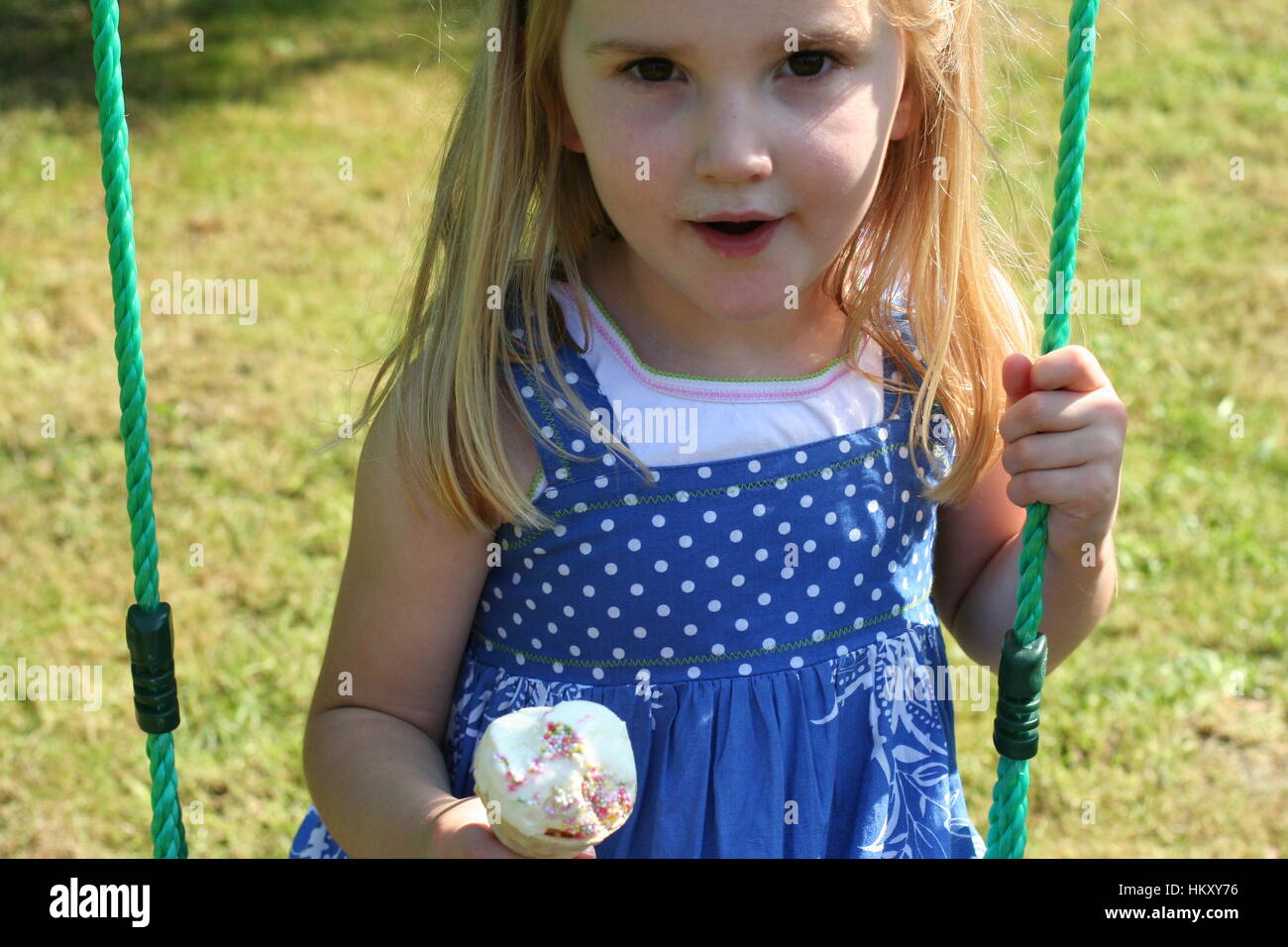 Petite Fille Blonde Avec Des Yeux Marron Enfant Kid S Amusant Assis Sur Une Balancoire Eating Ice Cream Cone Sur Un Jour D Ete Ensoleille Assez Doux Enfant Photo Stock Alamy
