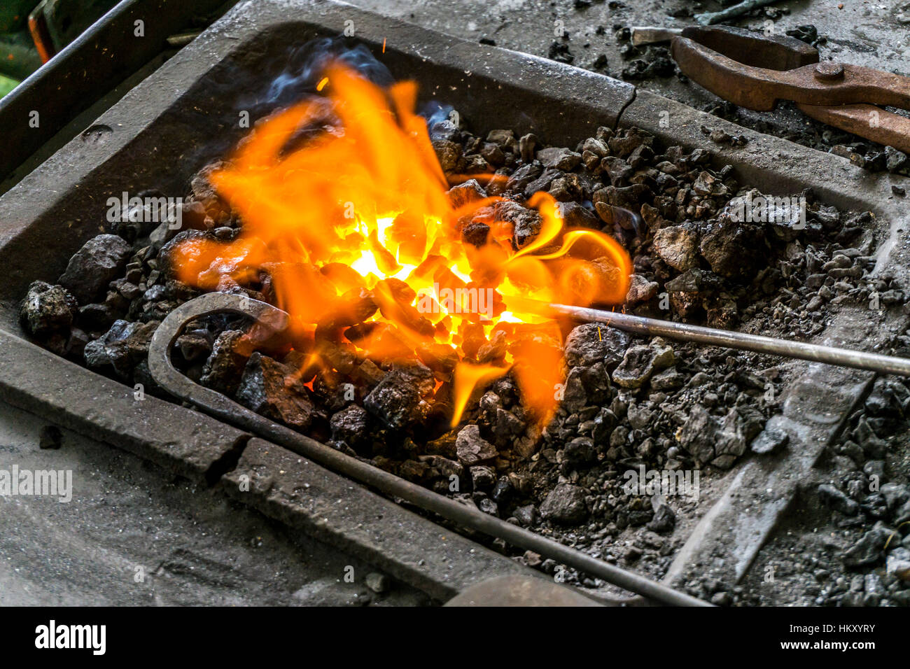 Le feu, braises dans une forge, la chaleur d'une tige métallique pour le forger plus tard, feu de charbon, Banque D'Images