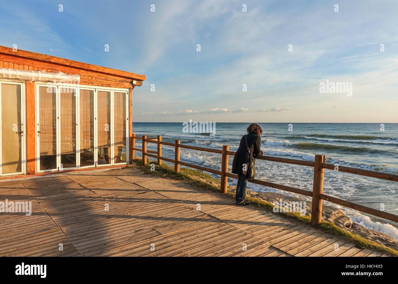 Femme seule sur une terrasse vide de plage méditerranéenne bar restaurant, Marbella, Andalousie, Espagne Banque D'Images