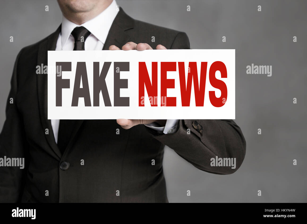 Fake News label est tenu par l'homme d'affaires. Banque D'Images