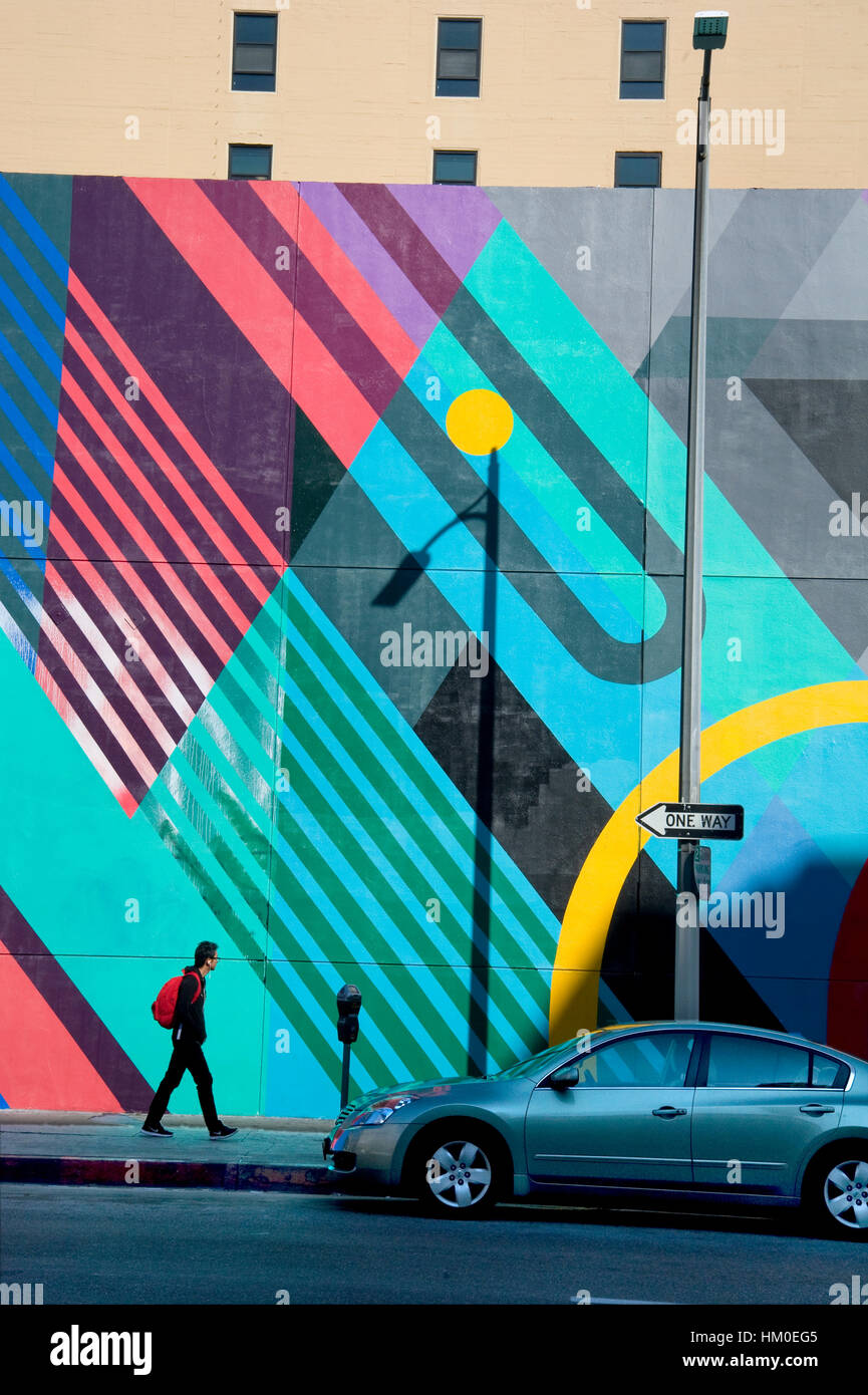 Homme marchant devant de grandes murales géométriques sur le mur dans le centre-ville de Los Angeles, Californie Banque D'Images