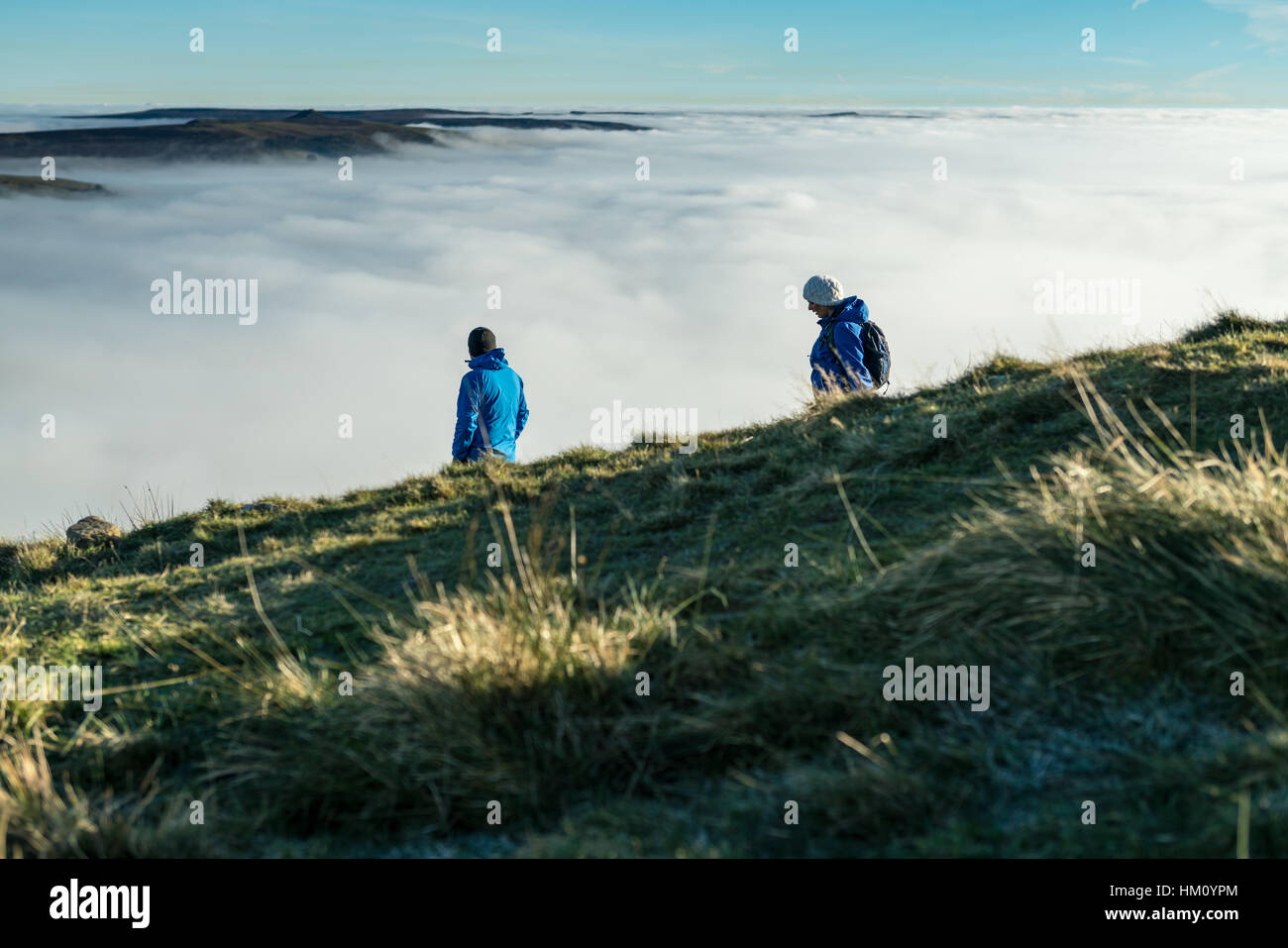 Homme et femme les randonneurs descendent du pic de Mam Tor, Peak District, l'espoir vallée sur un froid matin d'hiver Banque D'Images