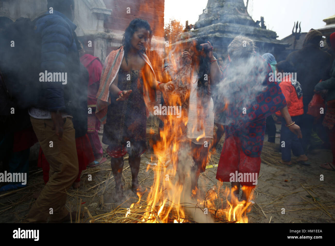 Kavre, au Népal. Jan 31, 2017. Les dévots hindous népalais se réchauffer près d'un feu de camp après avoir pris un bain pendant le mois saint-long Swasthani Bratakatha festival à Panauti, Kavre au Népal le mardi 31 janvier, 2017. Les dévots récitent la Sainte Écriture et les femmes de prier pour le bien-être de leurs conjoints en marchant pieds nus sur des centaines de kilomètres à différents sanctuaires tout au long du mois de jeûne. Credit : Skanda Gautam/ZUMA/Alamy Fil Live News Banque D'Images