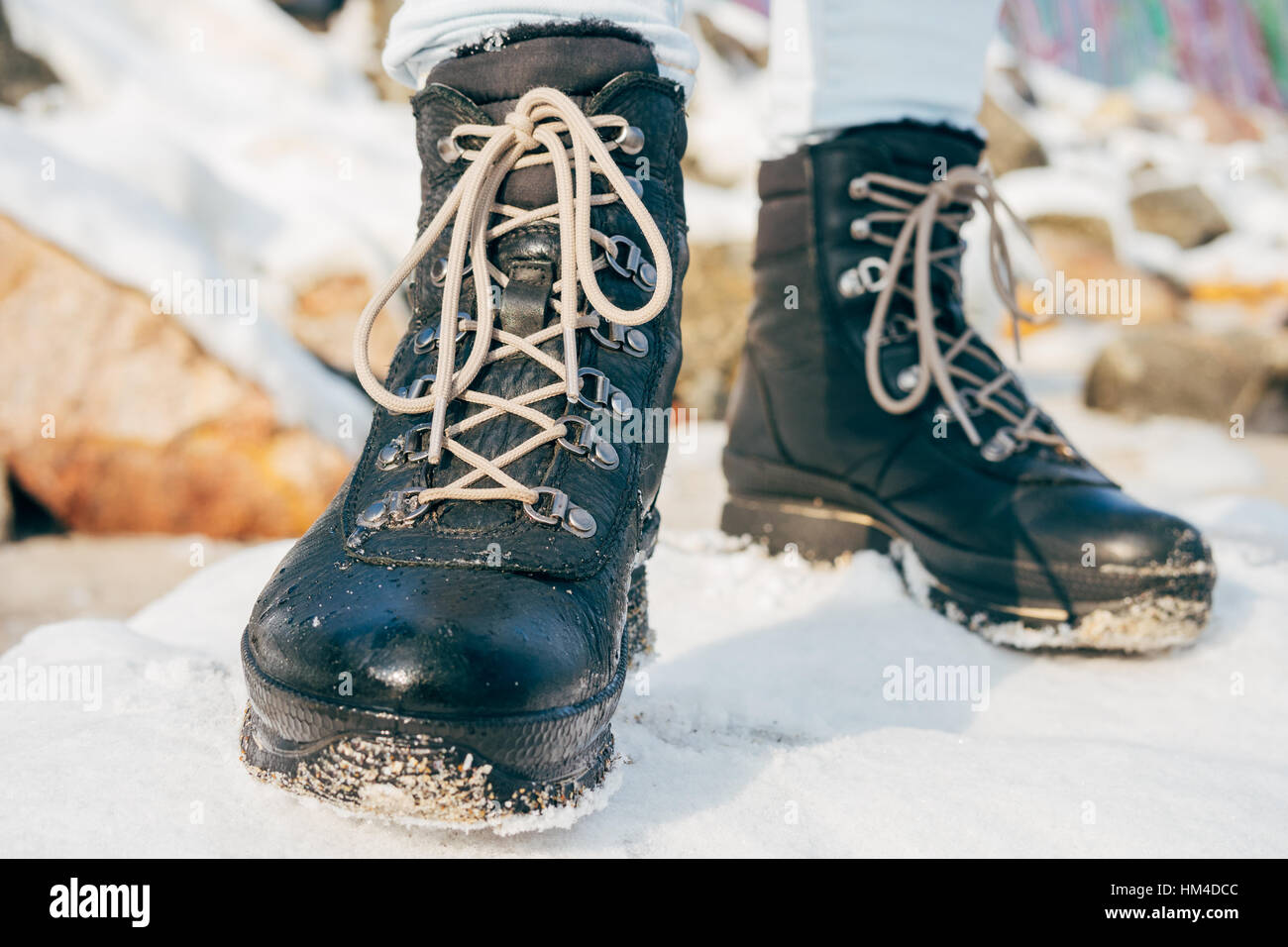 Les pieds dans les bottes d'hiver avec lacets debout dans la neige Banque D'Images