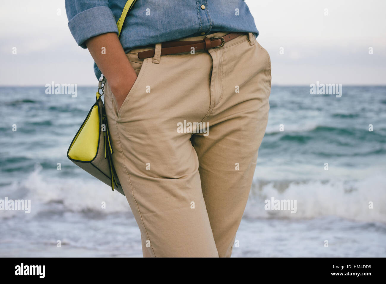 Femme en chemise en jean pantalon beige et marcher le long de la plage  Photo Stock - Alamy