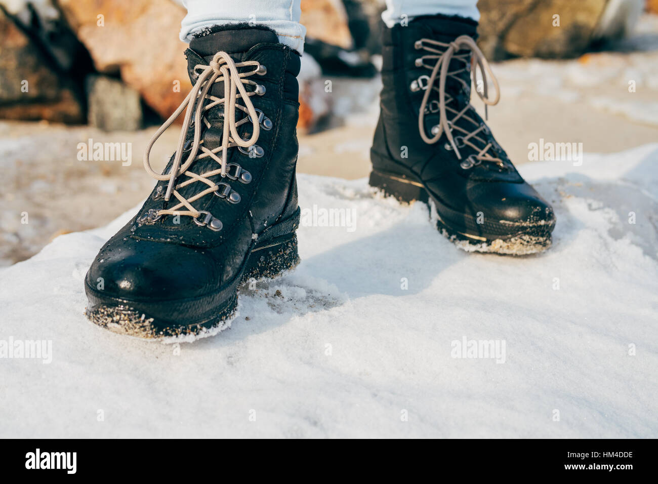 Les pieds dans les bottes d'hiver de haut standing dans la neige close-up Banque D'Images